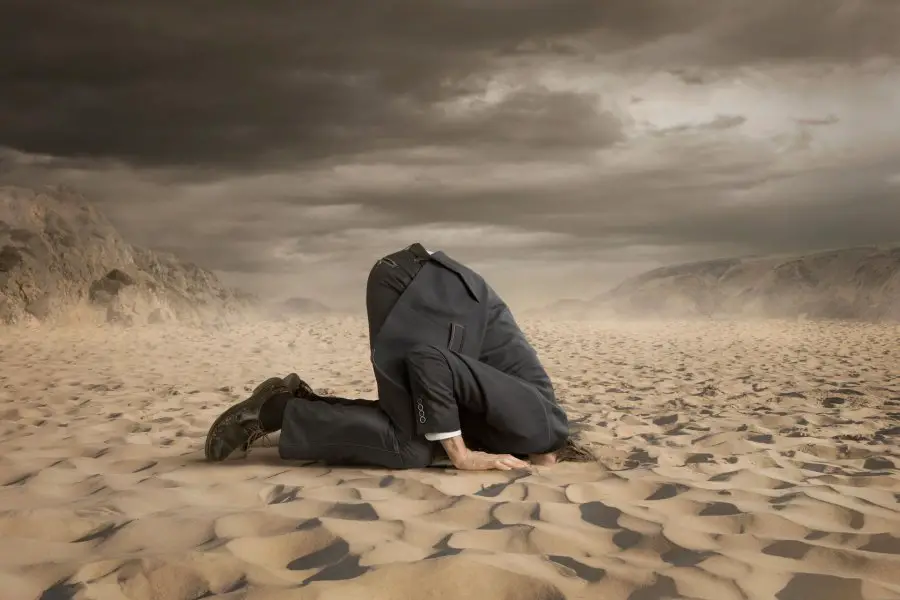 42776058 - young businessman hiding head in the sand