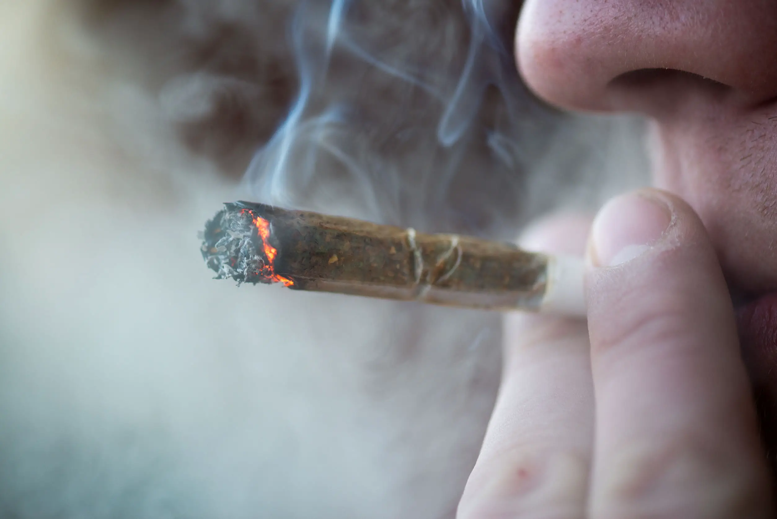 43934037 - man smoking marijuana cigarette soft drug in amsterdam, netherlands