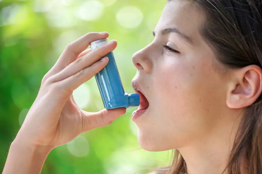 Portrait of a girl using asthma inhaler