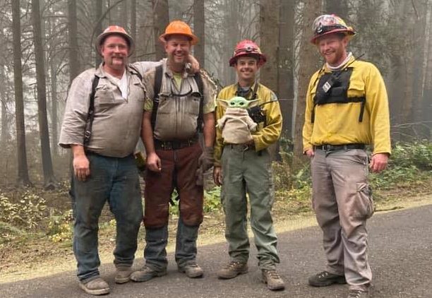 firefighters with a baby Yoda doll